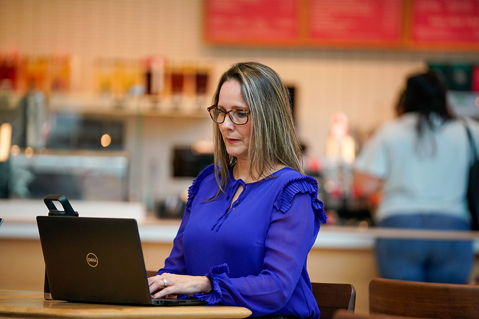 Student sitting at coffee shop with laptop